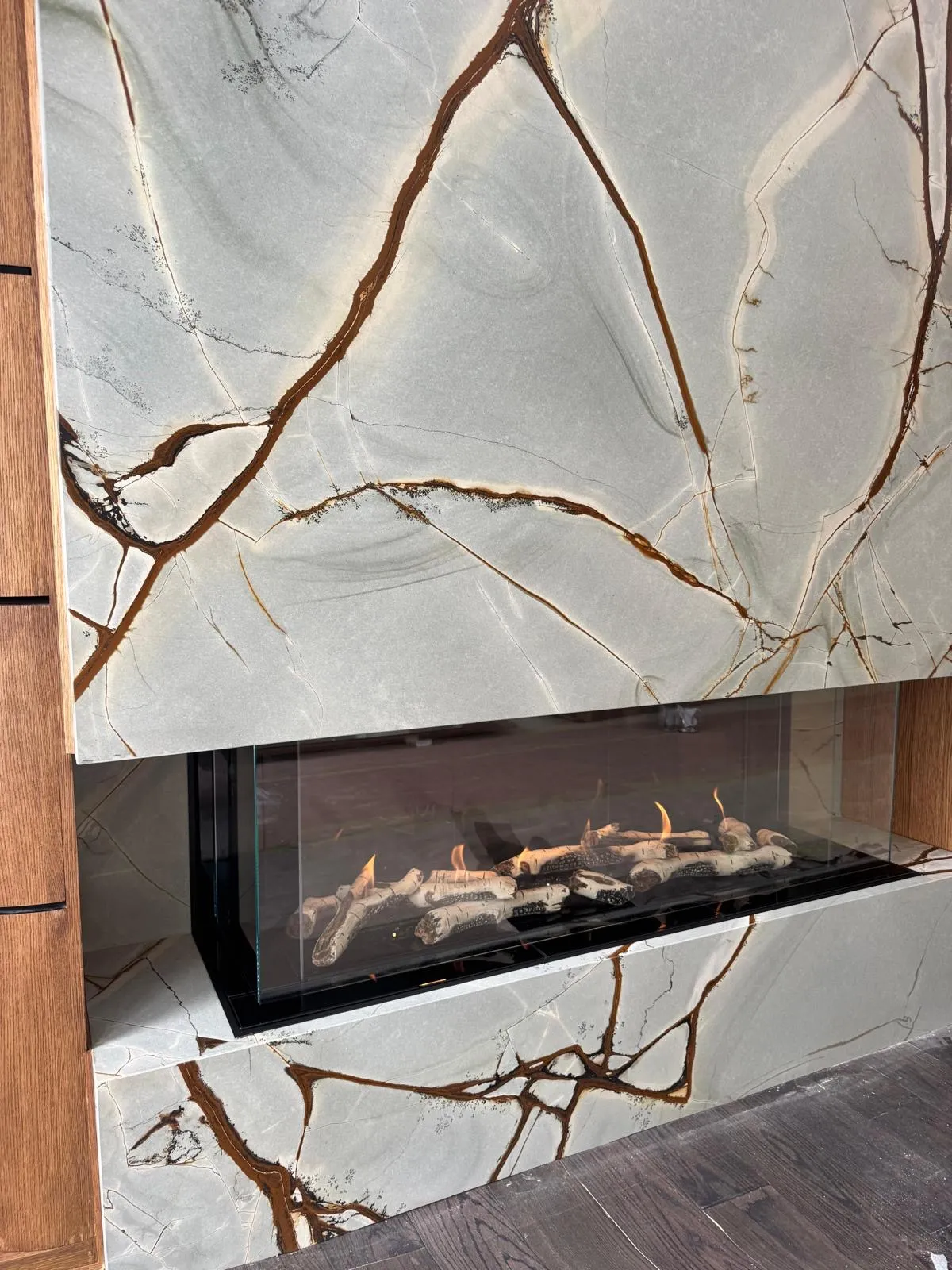 Marble fireplace with decorative branches on the hearth