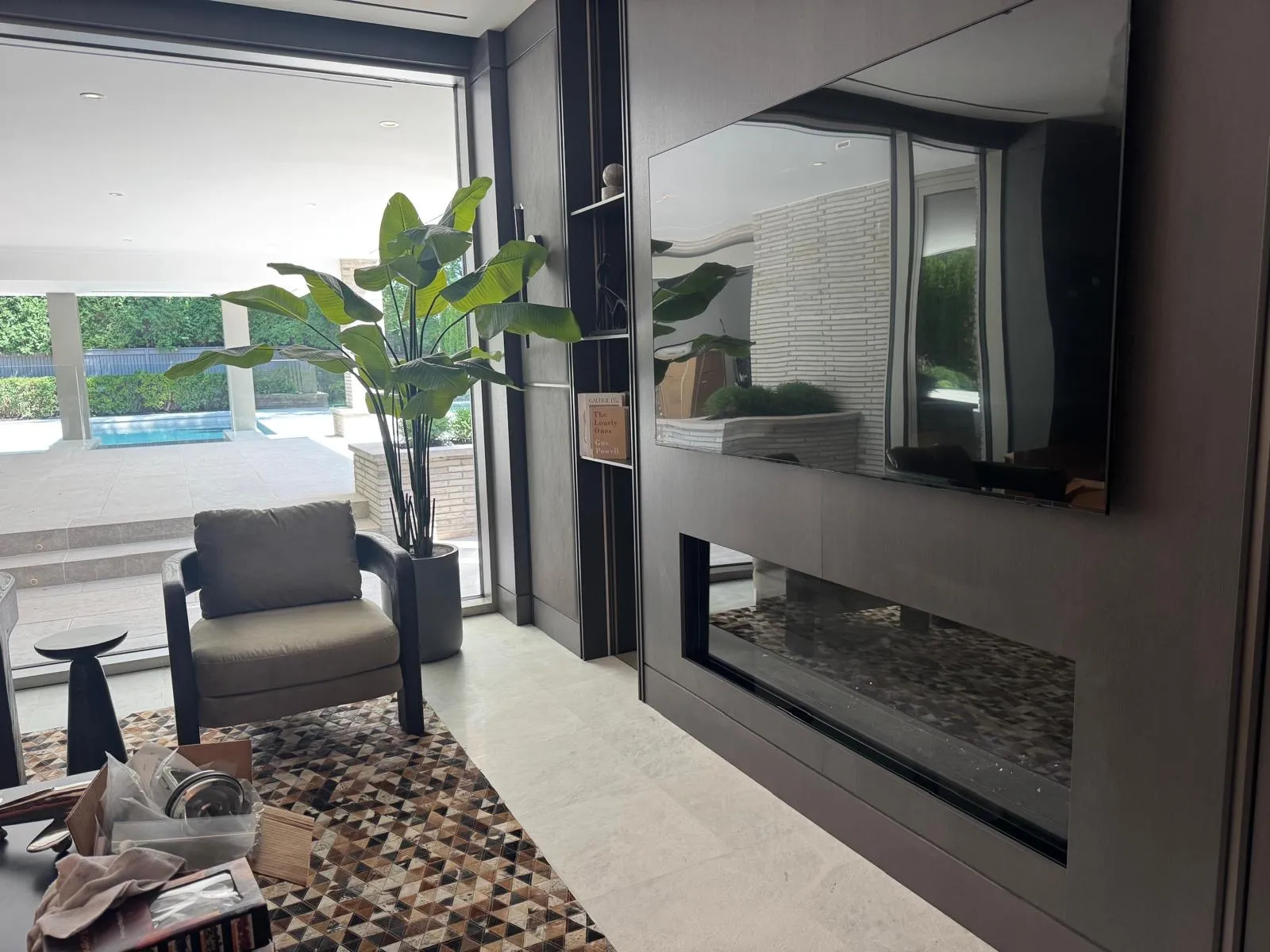 Wall-mounted TV over linear gas fireplace in wood panelling