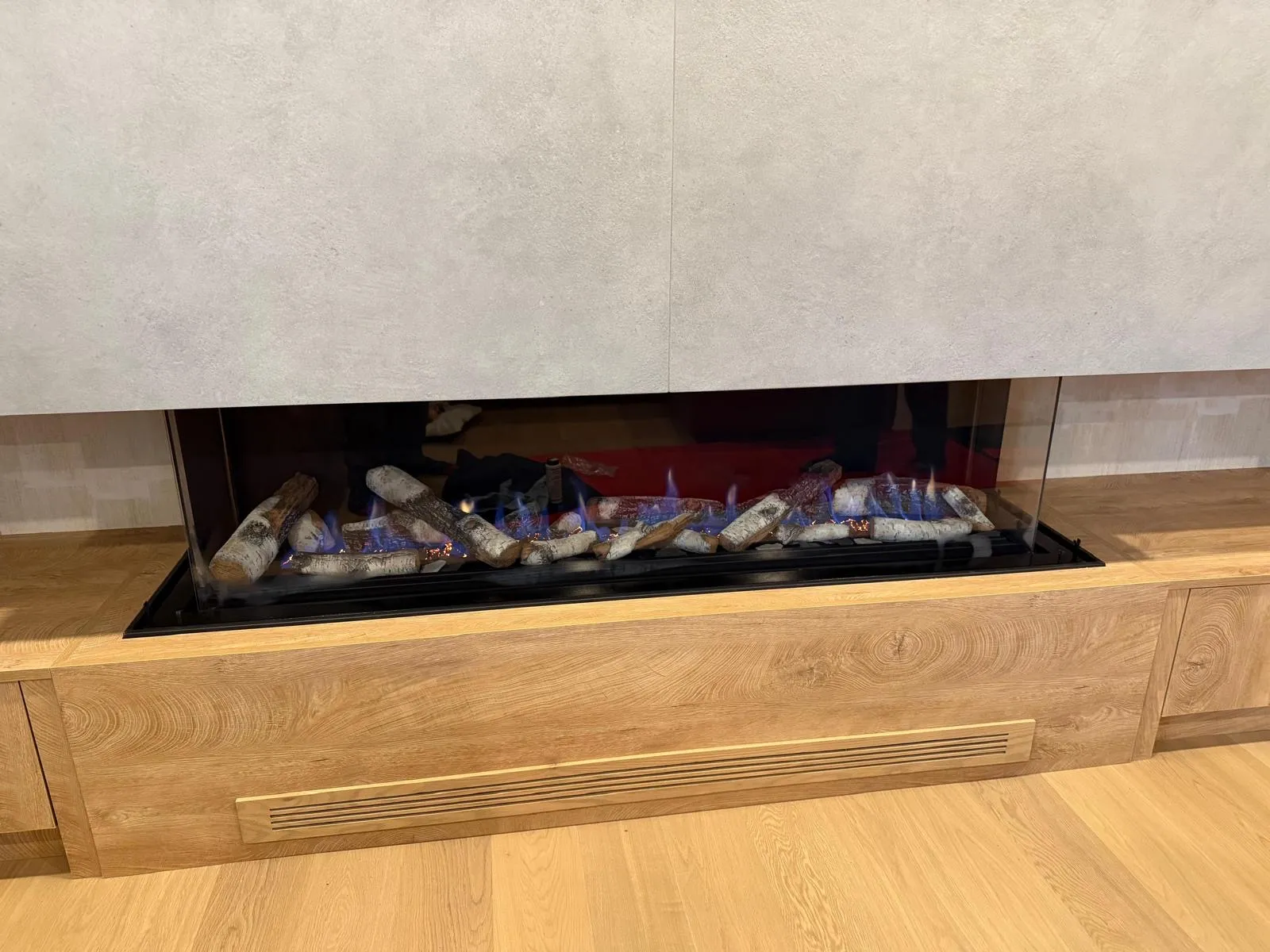 Linear gas fireplace in a warm wood-panel wall